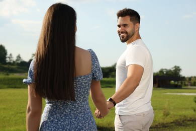 Photo of Romantic date. Beautiful couple walking outdoors on sunny day