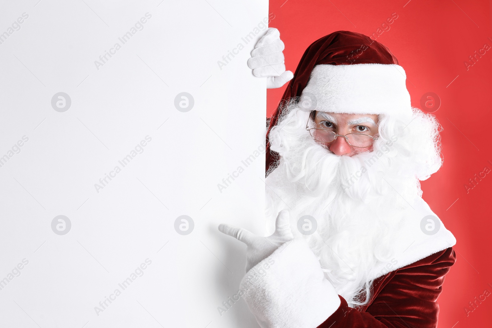 Photo of Santa Claus holding empty banner on red background