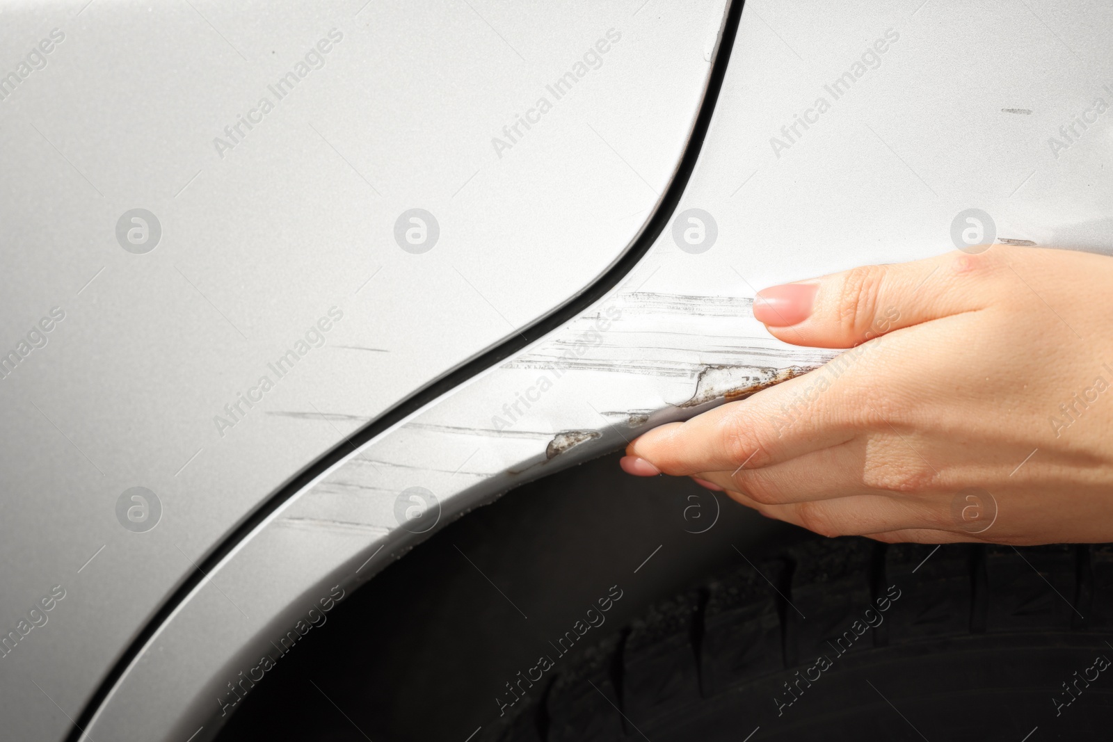 Photo of Woman near car with scratch, closeup view