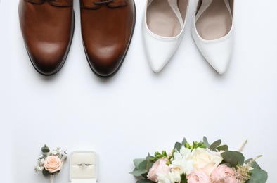 Composition with wedding shoes for bride and groom on white background, top view