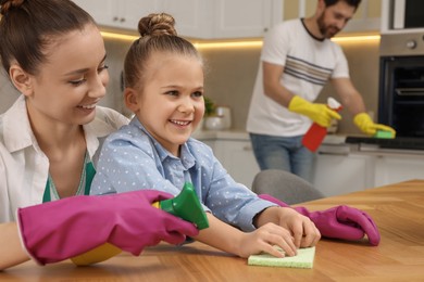 Photo of Spring cleaning. Happy family tidying up kitchen together