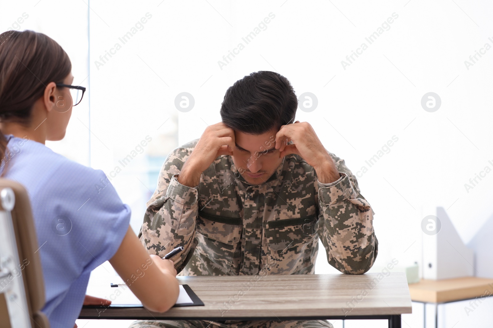 Photo of Psychotherapist working with male military officer in office