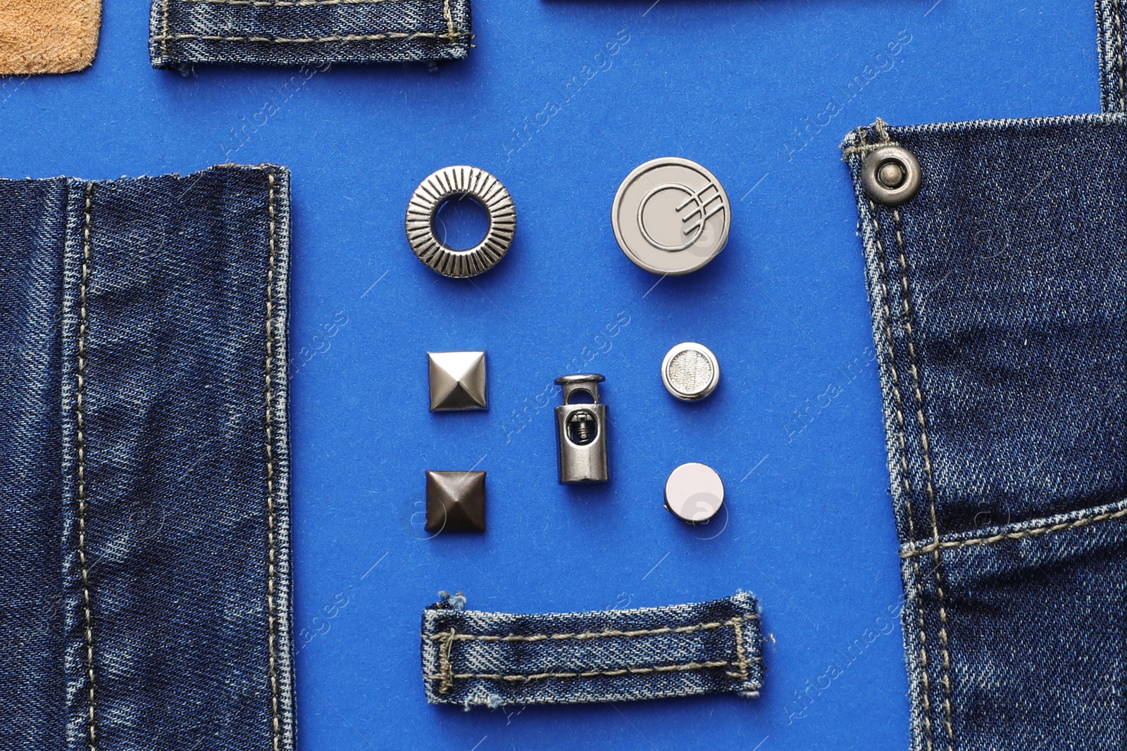 Photo of Flat lay composition with garment accessories and cutting details for jeans on blue background