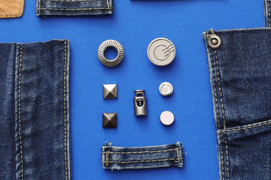 Photo of Flat lay composition with garment accessories and cutting details for jeans on blue background