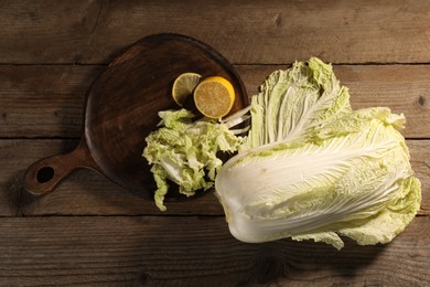 Photo of Fresh Chinese cabbage and lemon on wooden table, flat lay