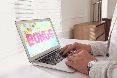 Image of Bonus gaining. Man using laptop at white table indoors, closeup. Illustration of falling coins and word on device screen