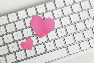 Keyboard with pink hearts on white table, top view. Valentine's day celebration