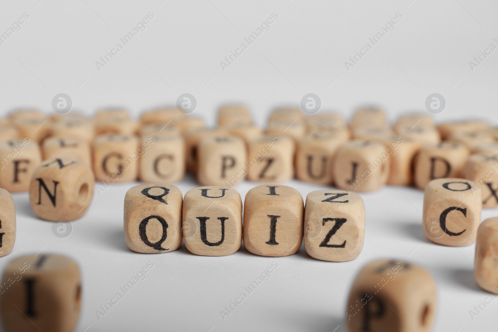 Photo of Wooden cubes with word Quiz on white background. Space for text