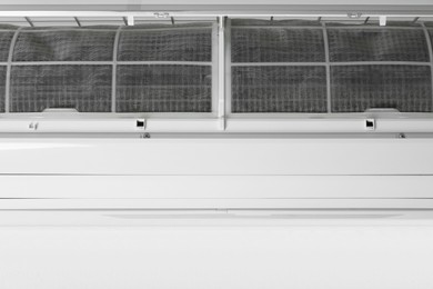 Photo of Modern air conditioner on white wall, closeup