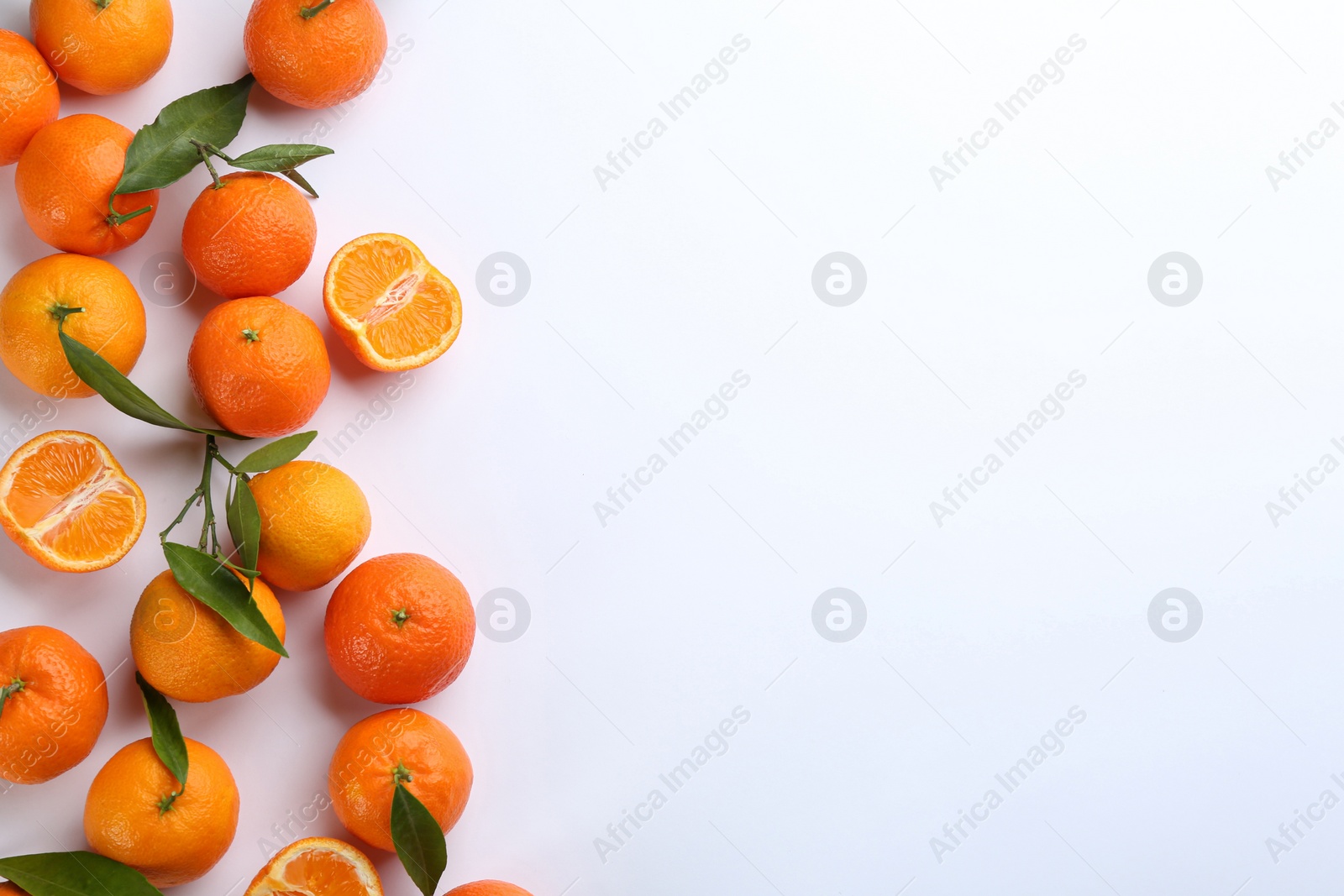 Photo of Fresh ripe tangerines with green leaves on white background, top view