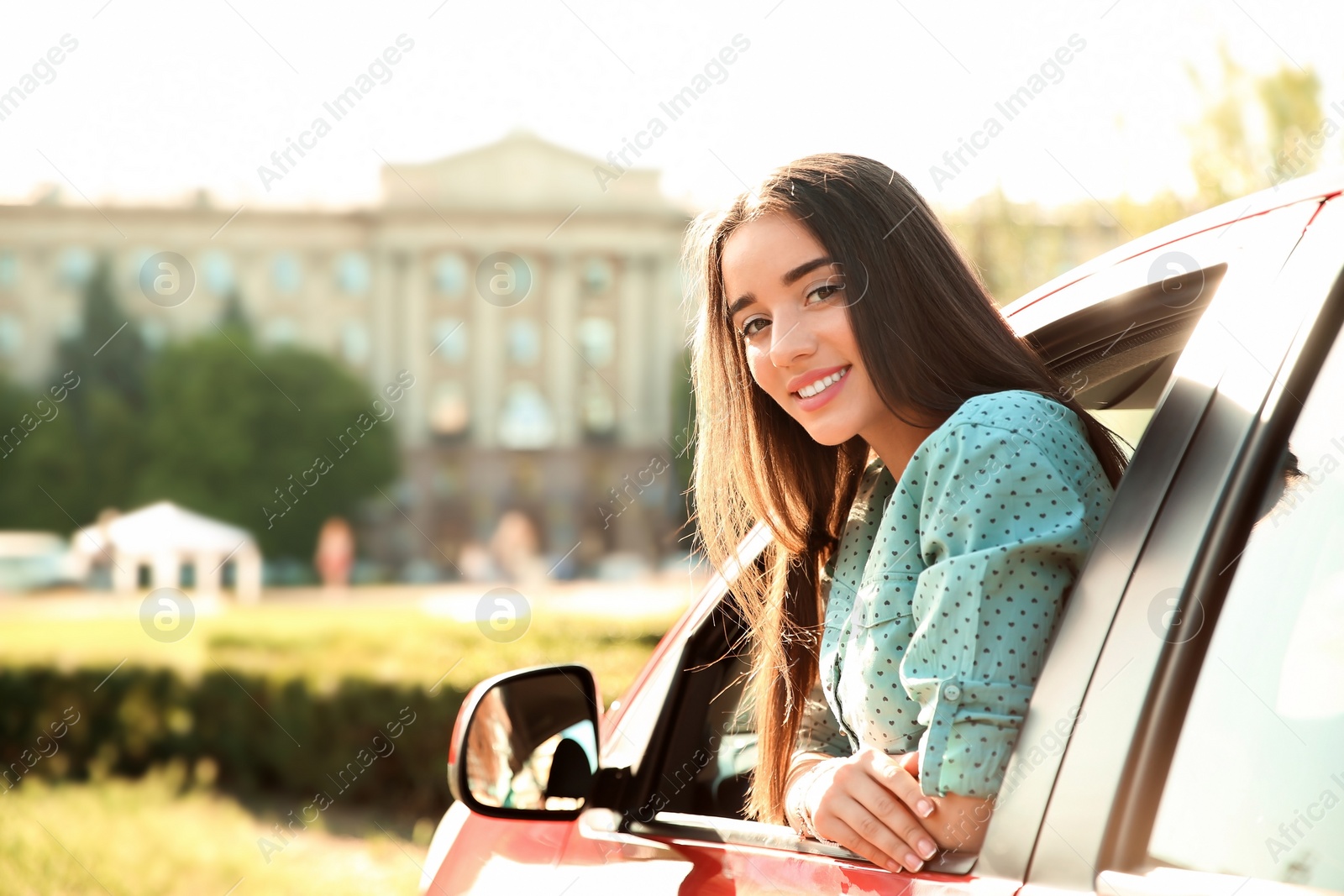 Photo of Young woman leaning out of car window