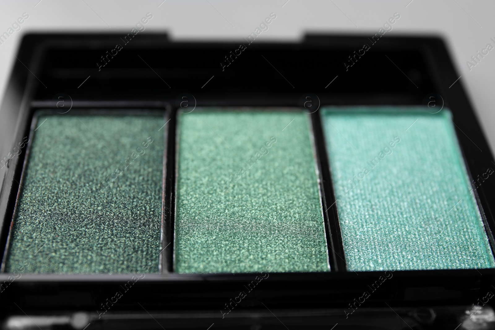 Photo of Beautiful eyeshadow palette on light gray background, closeup. Professional cosmetic product