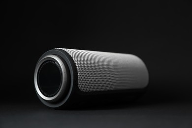 Photo of One portable bluetooth speaker on black background, closeup. Audio equipment