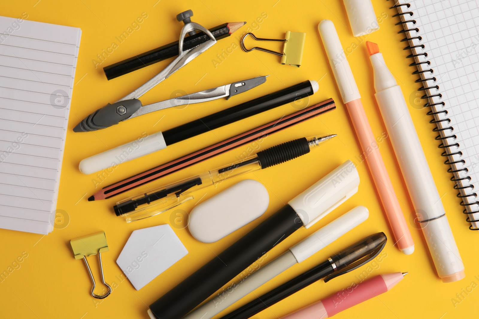 Photo of Flat lay composition with notebooks and other school stationery on orange background. Back to school