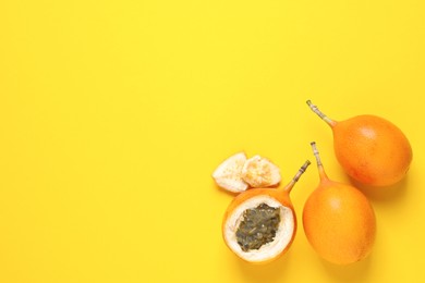 Delicious ripe granadillas on yellow background, flat lay. Space for text