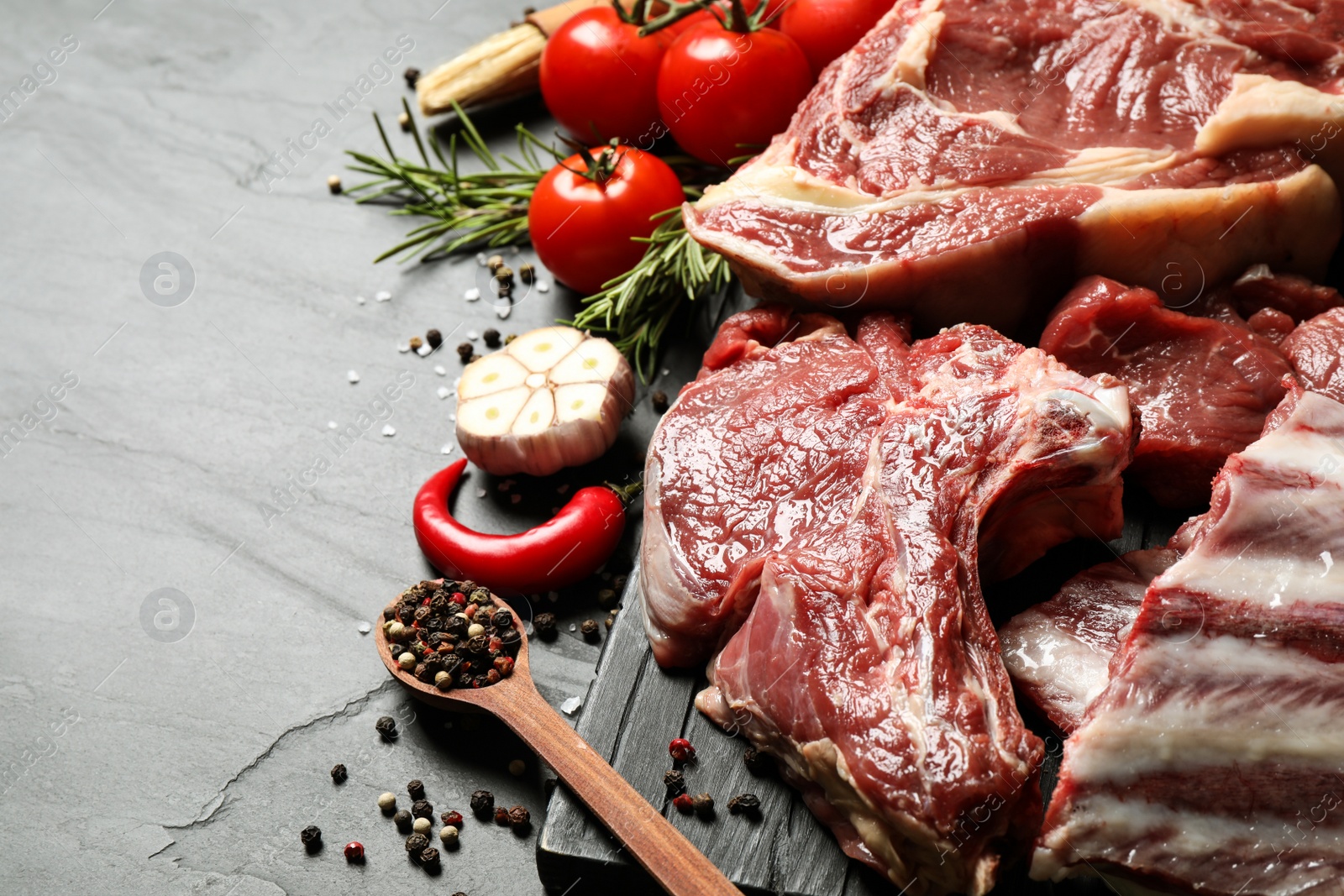 Photo of Fresh raw meat and spices on grey table, closeup