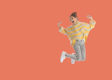 Image of Cute girl jumping on coral background, space for text