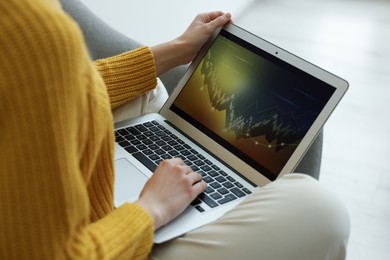 Photo of Woman working with laptop indoors, closeup. Forex trading