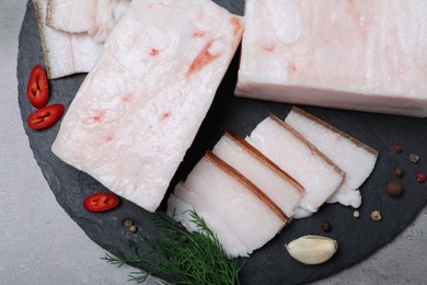 Pork fatback with spices served on grey table, top view