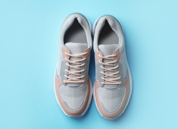 Pair of stylish sneakers on color background, top view