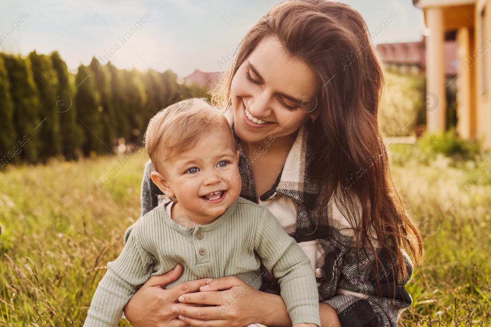 Image of Happy mother with her cute baby at backyard on sunny day