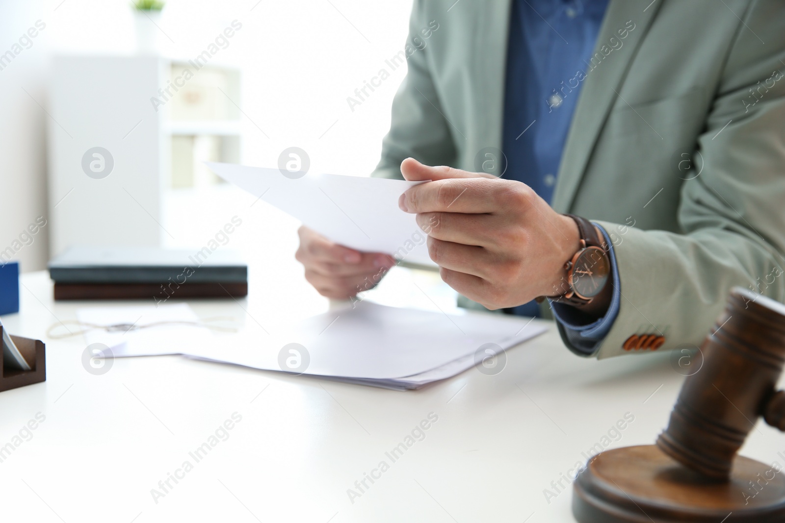 Photo of Notary working with papers at table in office, closeup. Law and justice concept