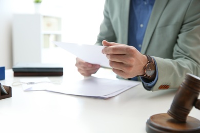 Notary working with papers at table in office, closeup. Law and justice concept