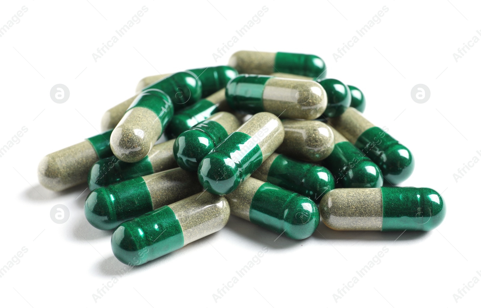 Photo of Heap of green spirulina capsules on white background. Alternative medicine