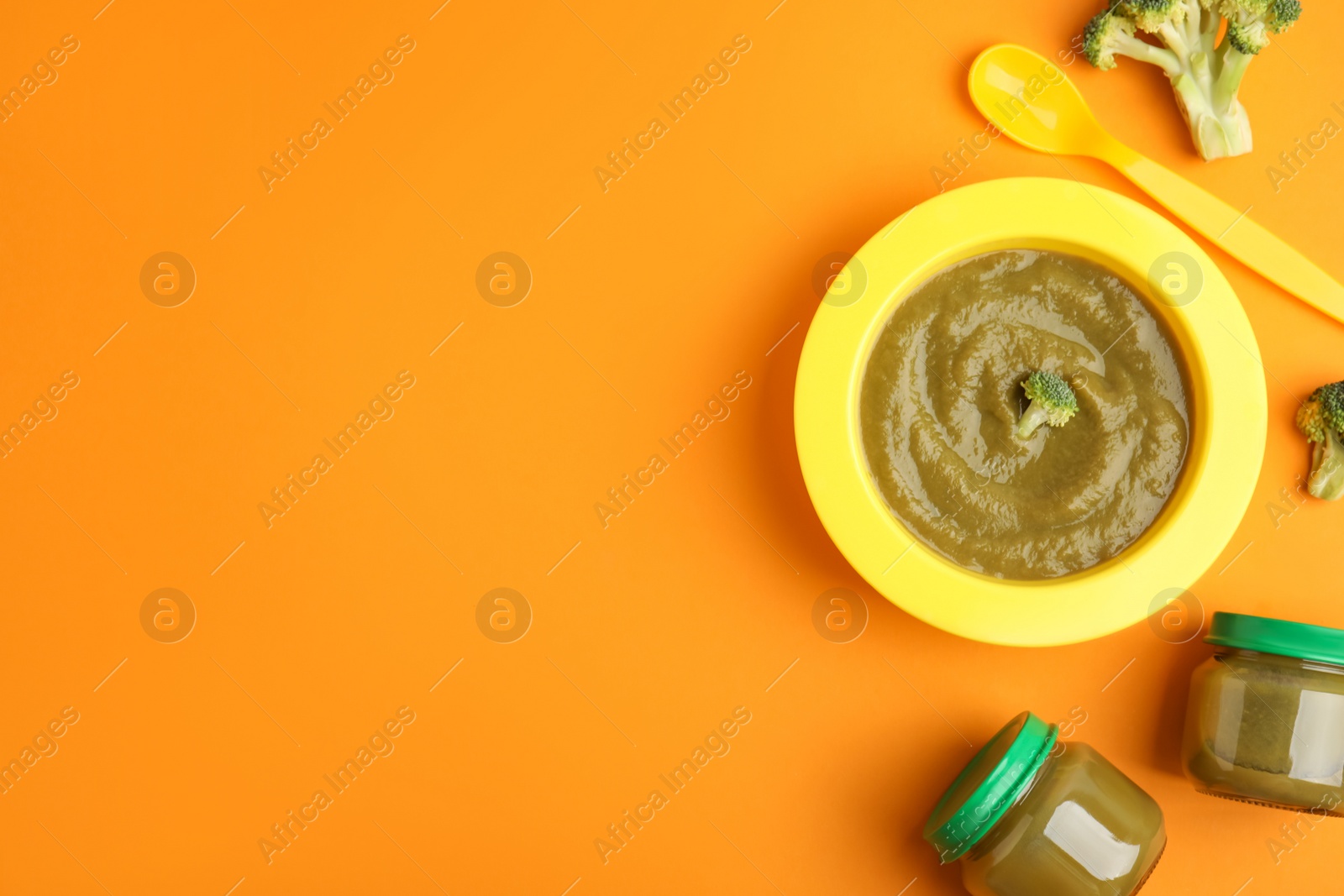 Photo of Flat lay composition with healthy baby food and broccoli on orange background. Space for text