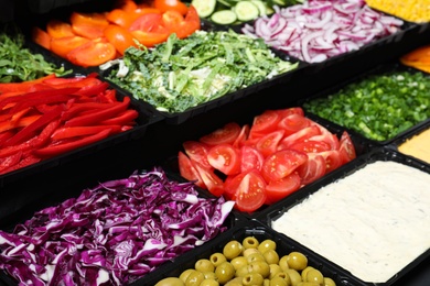 Salad bar with different fresh ingredients as background