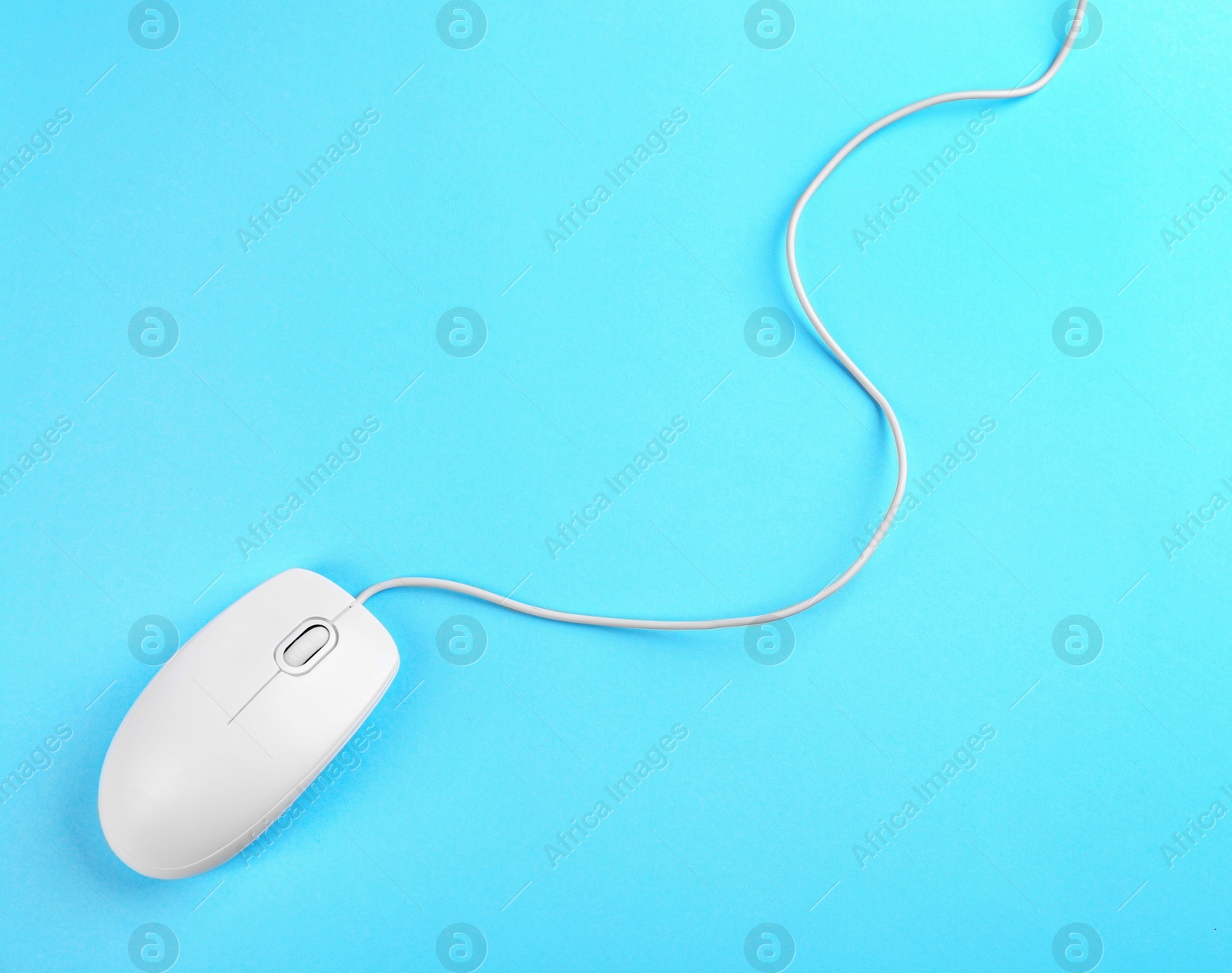 Photo of Modern wired mouse on light blue background, top view