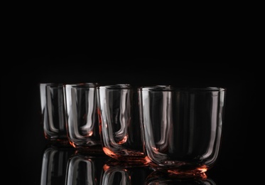 Photo of Empty colorful whiskey glasses on black background