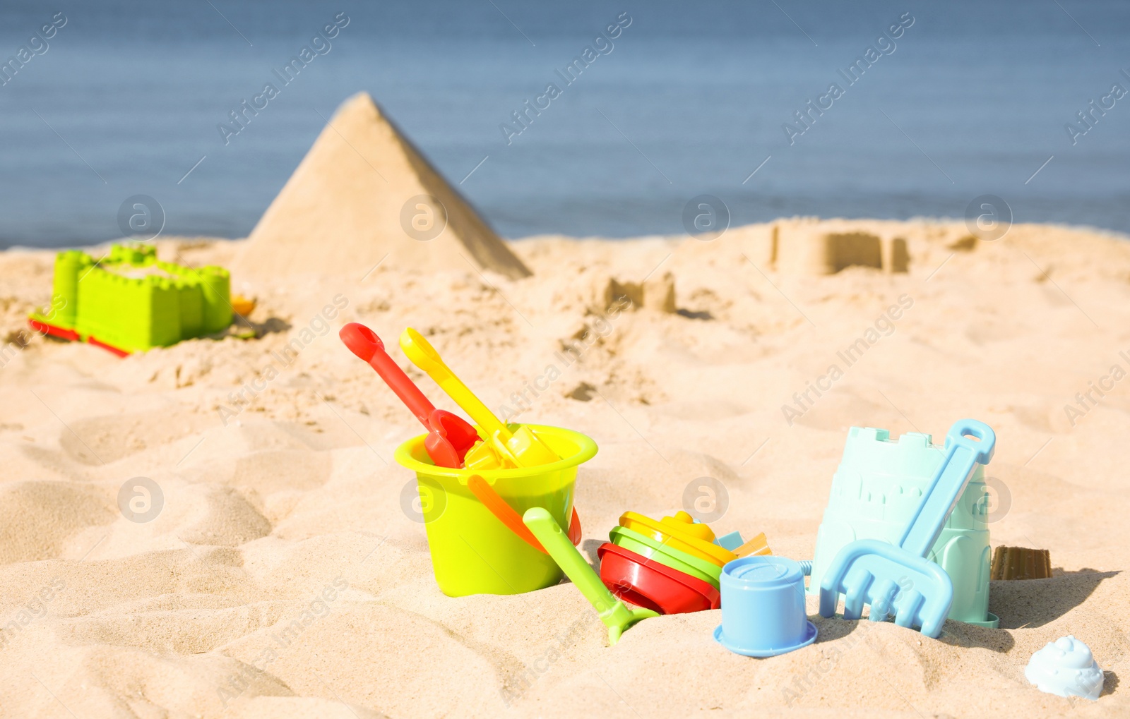 Photo of Different child plastic toys on sandy beach