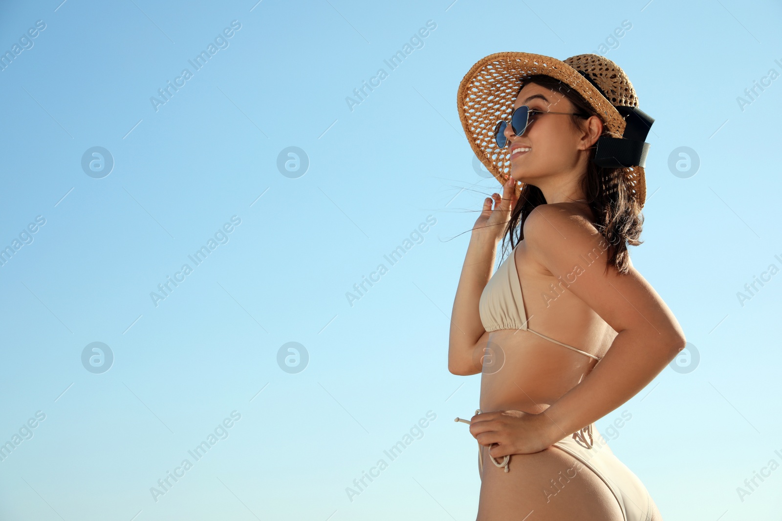 Photo of Beautiful young woman with attractive body against blue sky. Space for text