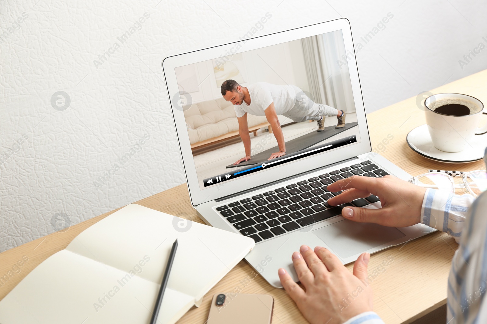 Image of Woman watching morning exercise video on laptop at table, closeup