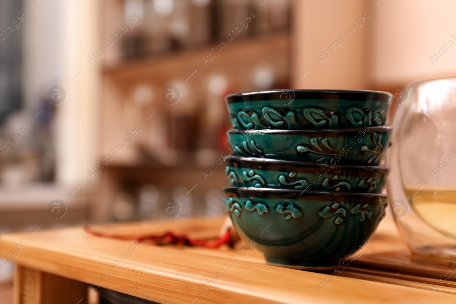 Photo of Stack of cups for traditional tea ceremony on wooden table indoors