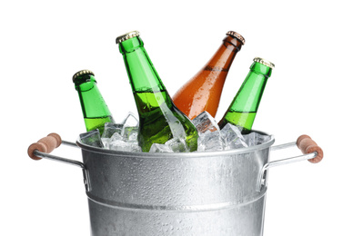 Photo of Metal bucket with bottles of beer and ice cubes isolated on white