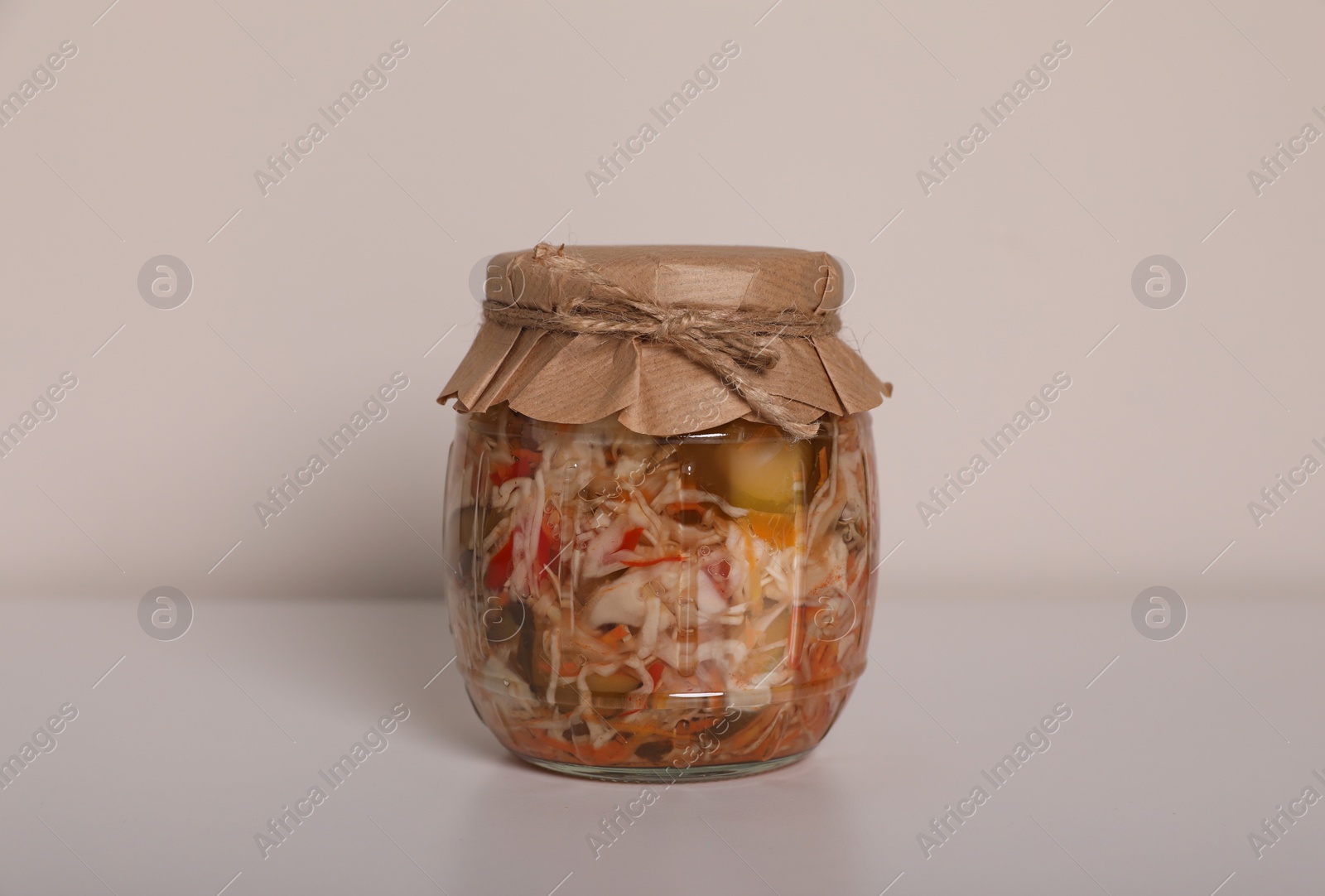 Photo of Jar of tasty pickled vegetable salad on white background