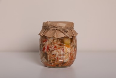 Jar of tasty pickled vegetable salad on white background