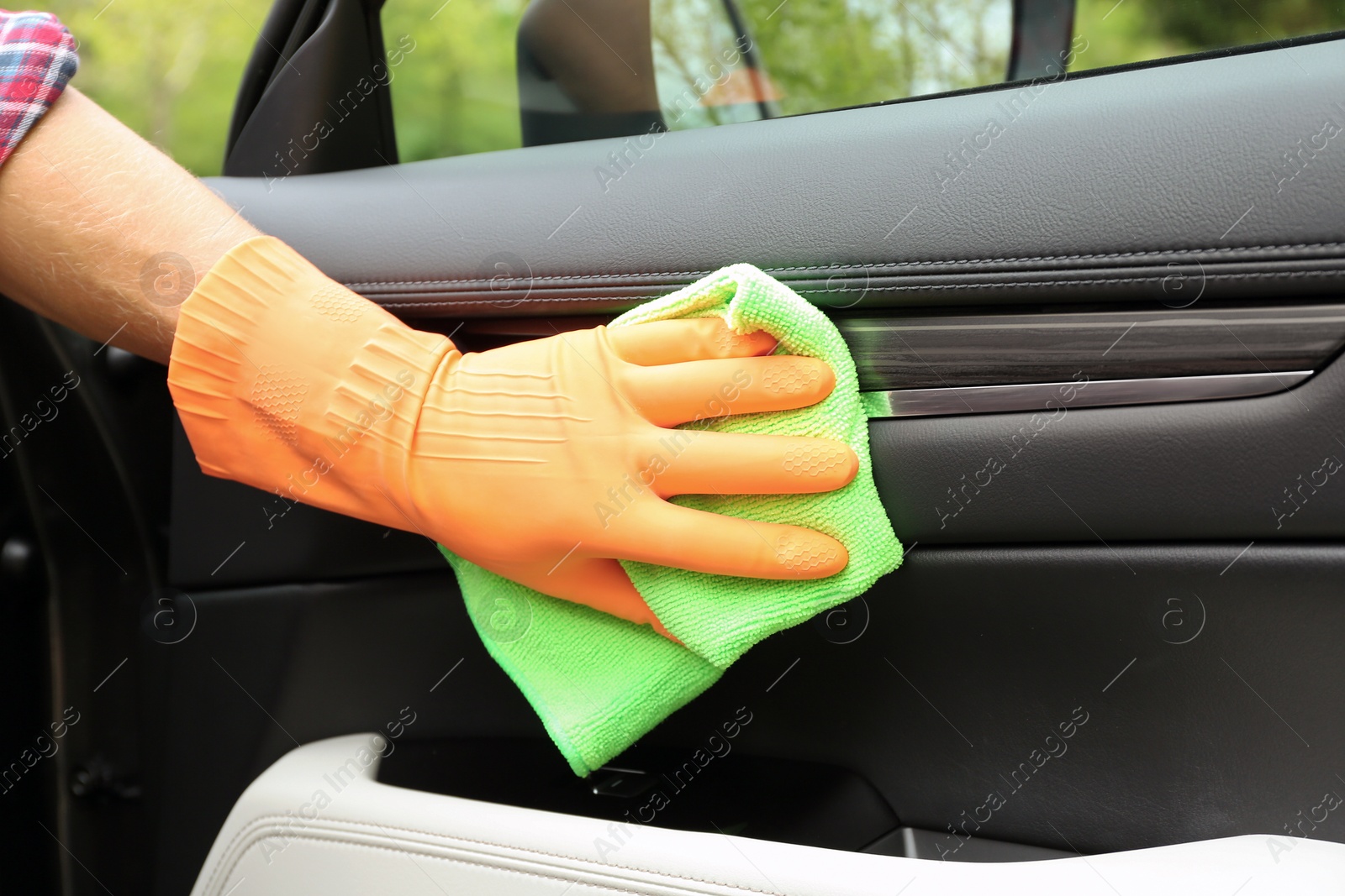 Photo of Man washing car door from inside with rag, closeup
