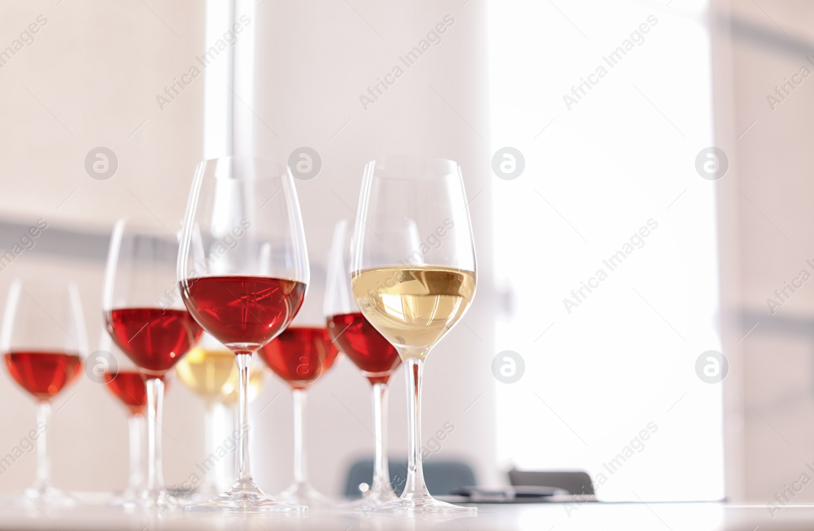 Photo of Glasses with delicious wine on table indoors