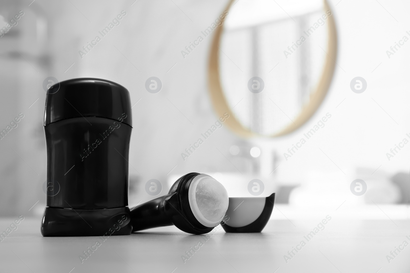 Photo of Different deodorants on table in bathroom. Space for text