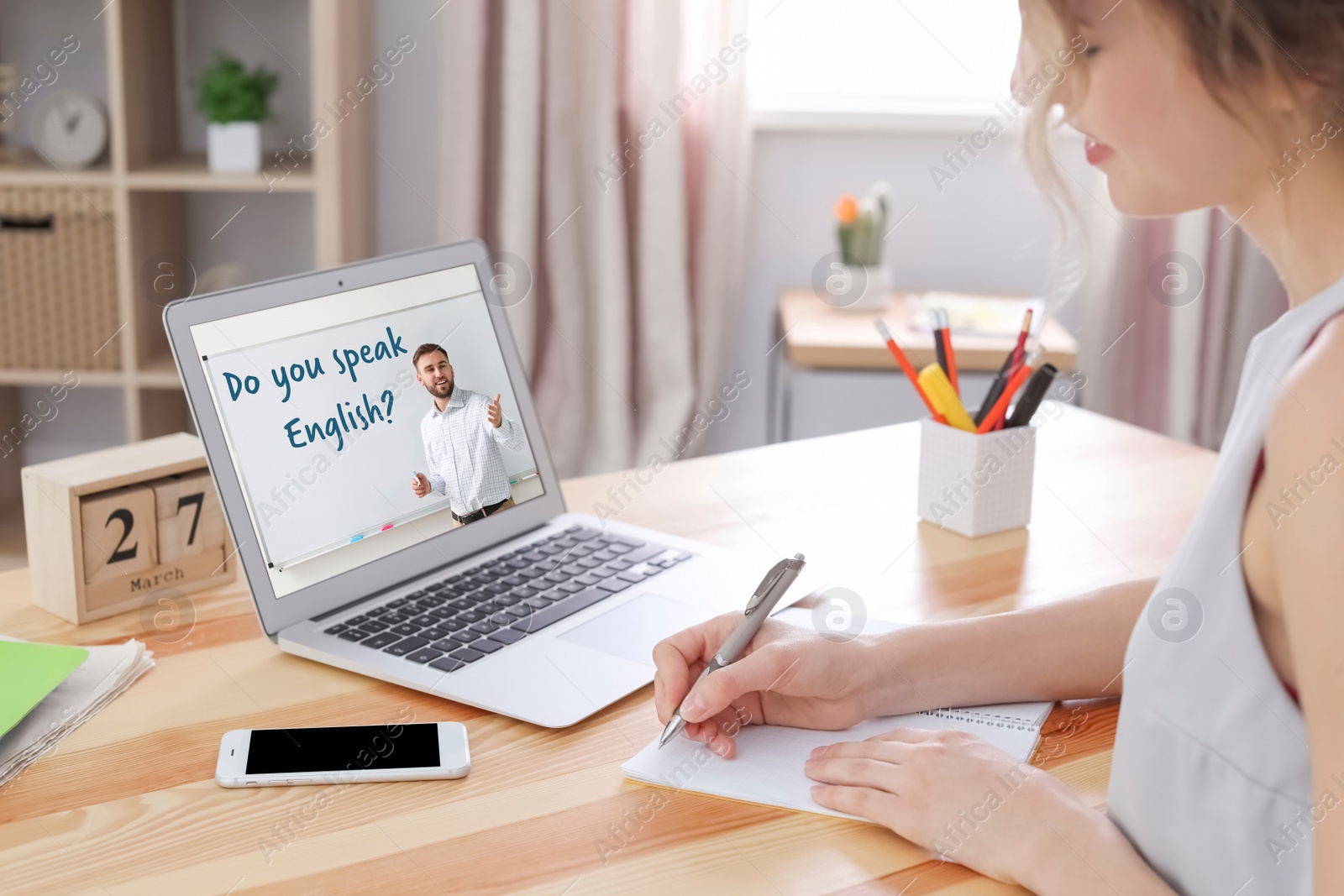 Image of Young woman using laptop for online English lesson with teacher at home, closeup