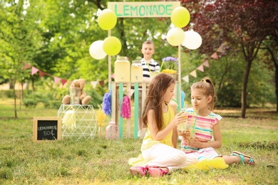 Photo of Little girls with natural lemonade in park