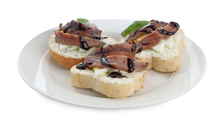 Delicious bruschettas with anchovies, eggs, basil and sauce on white background