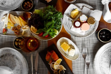 Photo of Different delicious food served on wooden table, flat lay
