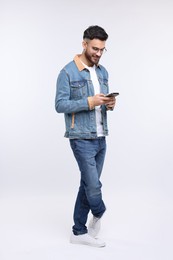 Photo of Handsome man using smartphone on white background