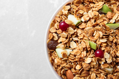 Photo of Tasty muesli with apples and berries on light table, top view. Healthy breakfast