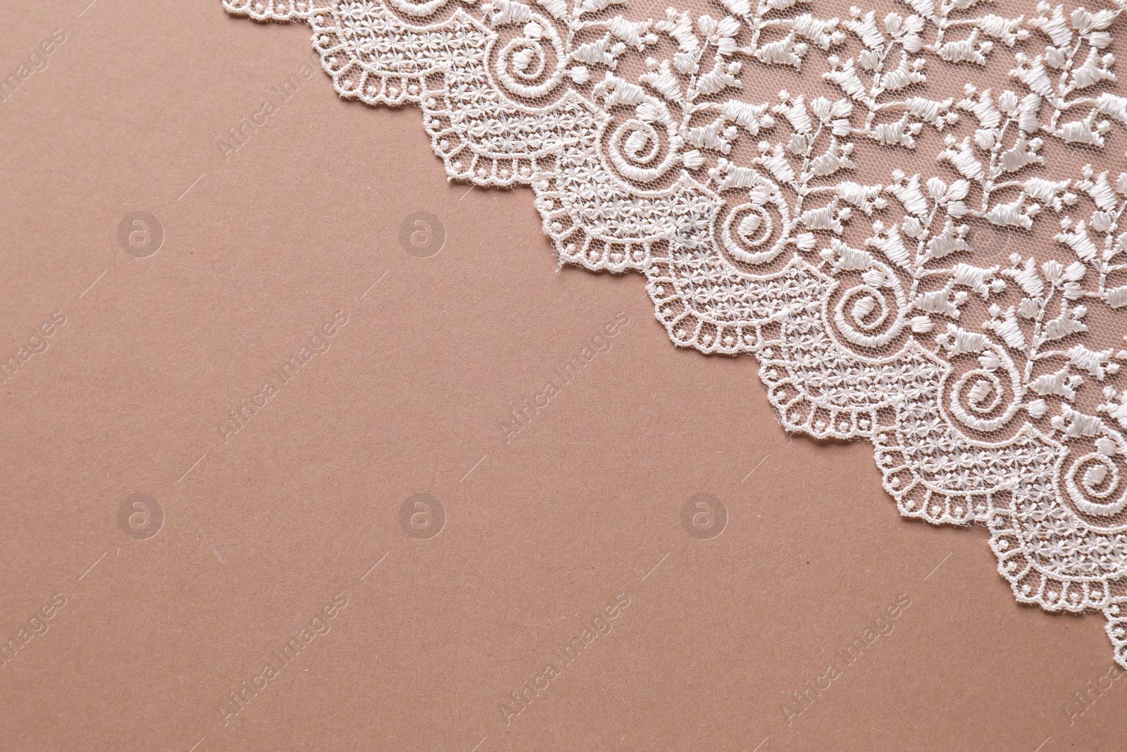 Photo of White lace on beige background, top view. Space for text