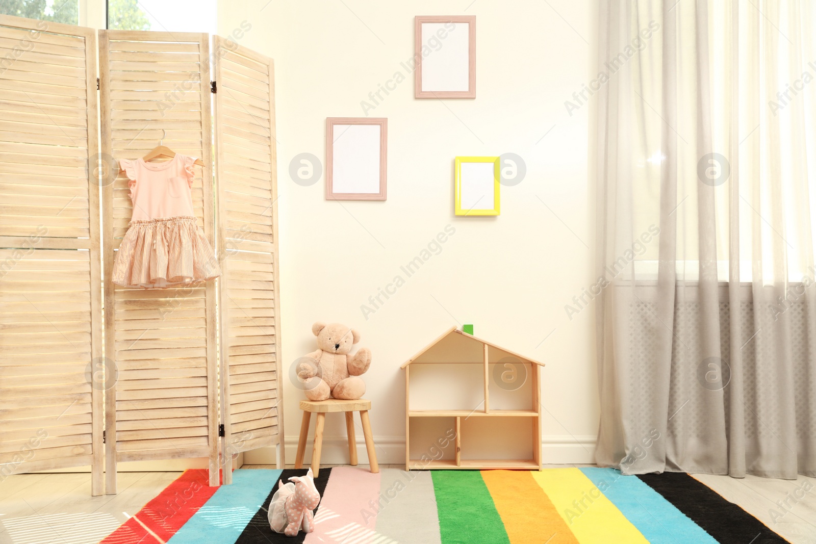 Photo of Modern folding screen in stylish baby room interior